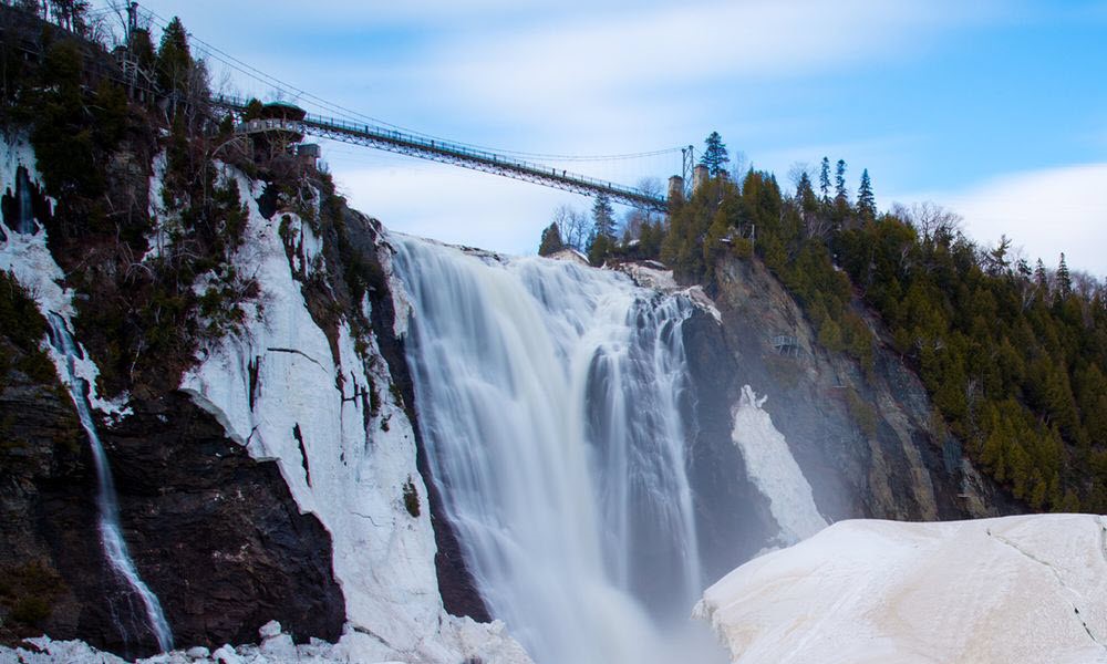 Snowy waterfall with a bridge