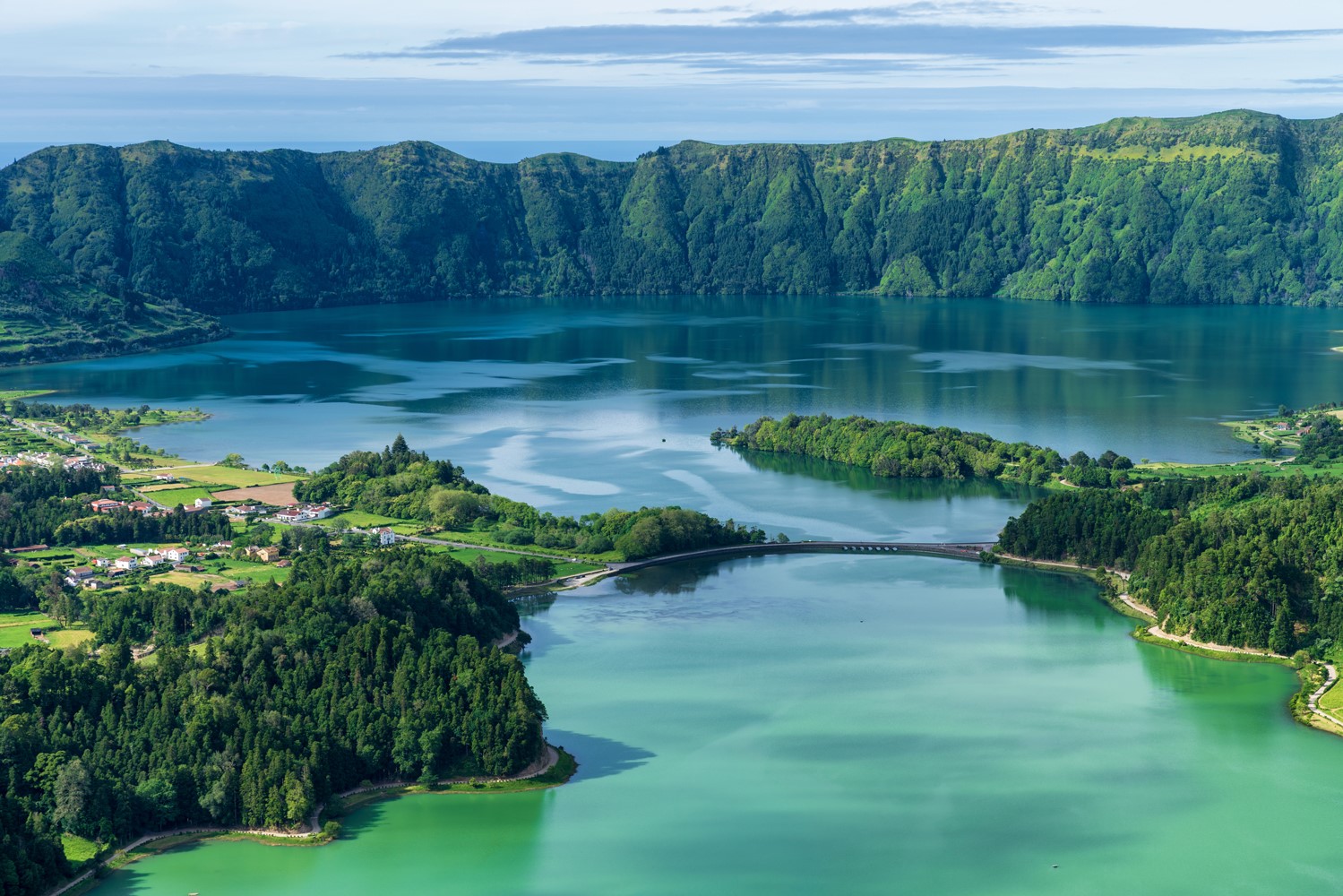 Crater lake with twin blue green waters surrounded by green hills