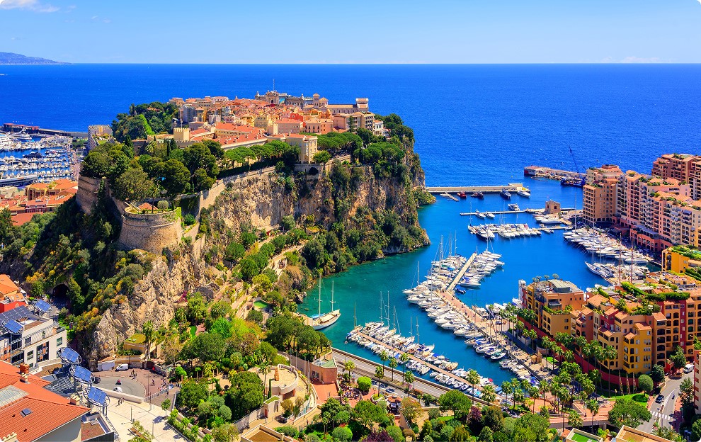Aerial view of cliffside coastal city with marina and blue sea
