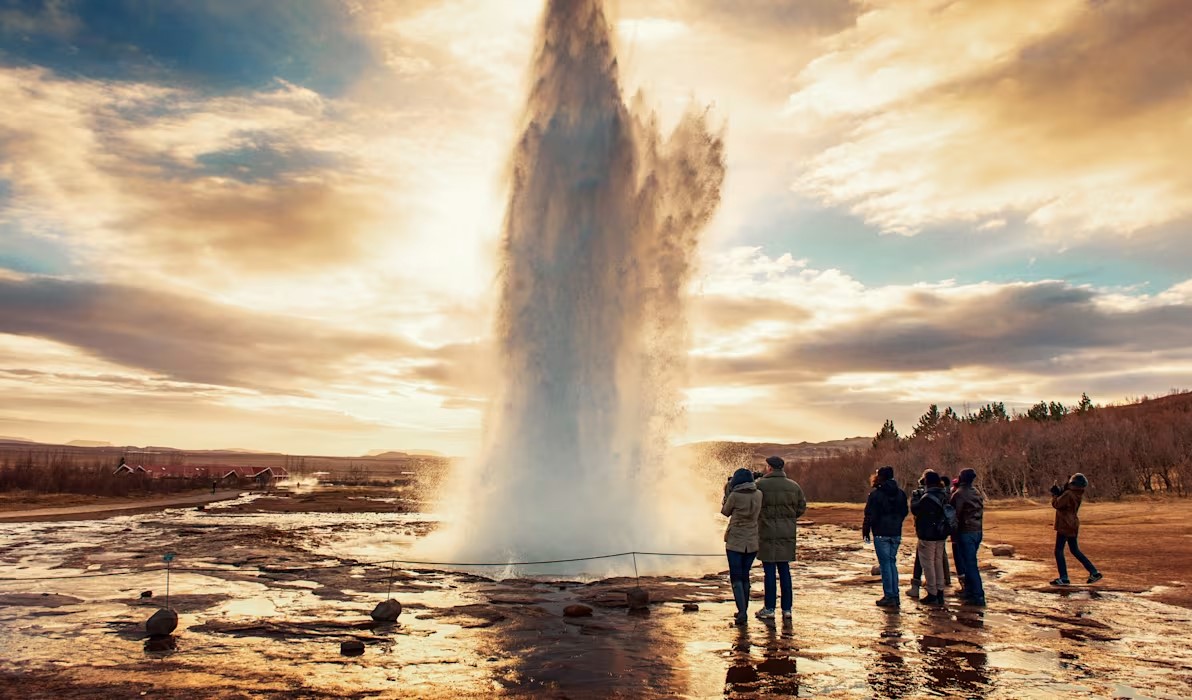 Geyser erupting with people watching nearby